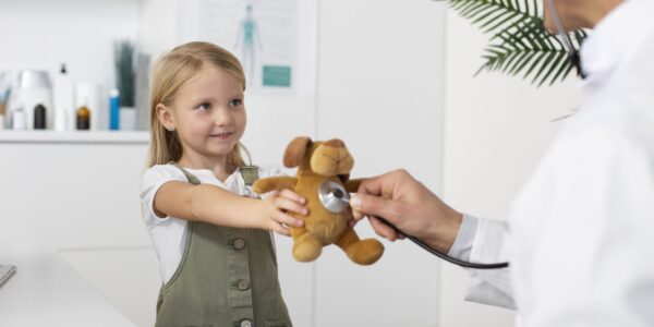 male-doctor-examining-young-girl-s-teddy-bear-toy-appointment